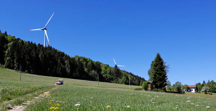 Sur les crêtes du Jura, des éoliennes majestueuses se dressent vers le ciel
